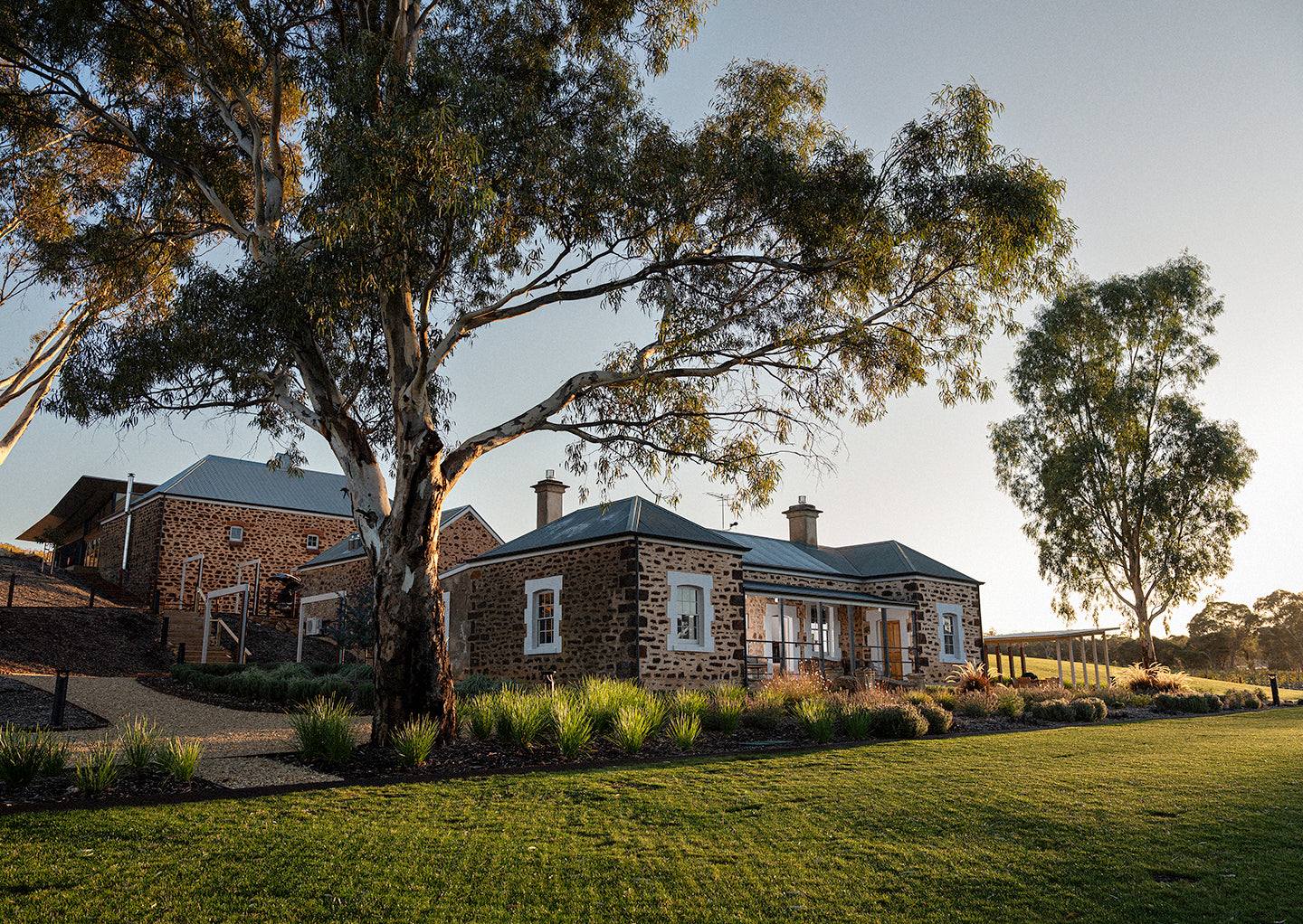 Stone building with trees and a clear sky, Torbrecks private Hillside estate, in the Southern Barossa Valley.