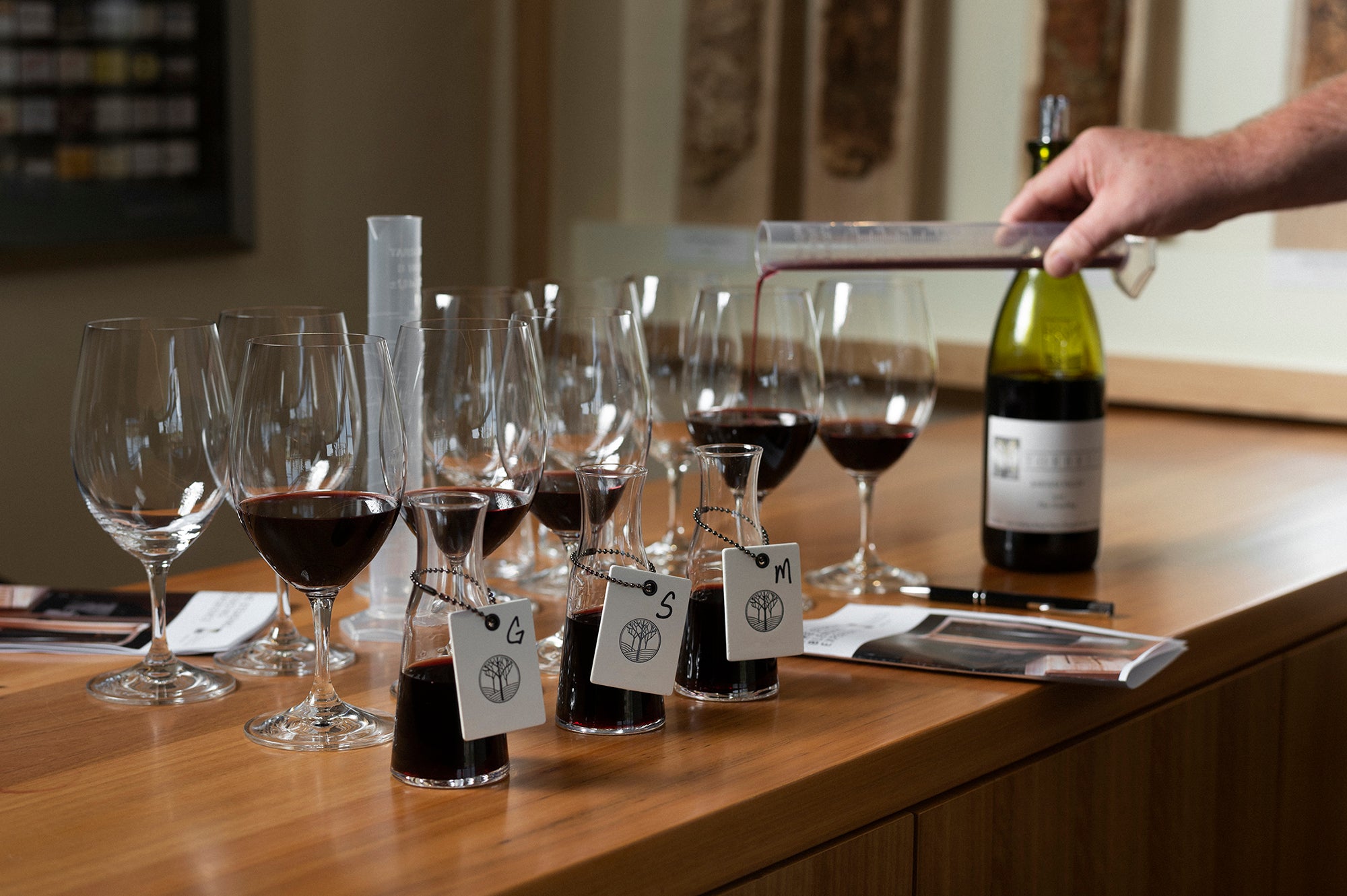 Wine tasting setup with glasses and a bottle on a wooden table. GSM, Steading blending experience
