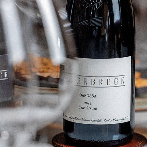 Two bottles of Struie wine with wine glasses on a table.